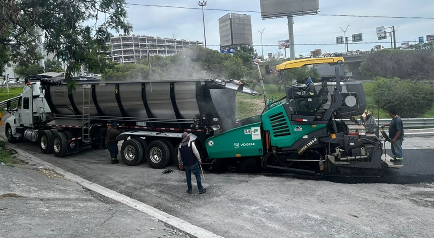 Flowboy descargando mezcla asfáltica directamente en una pavimentadora Vögele